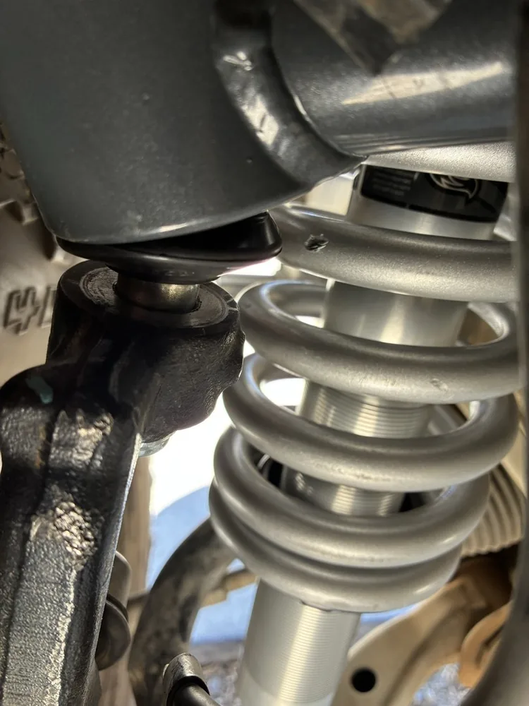 A coilover shock with a gray spring under a truck