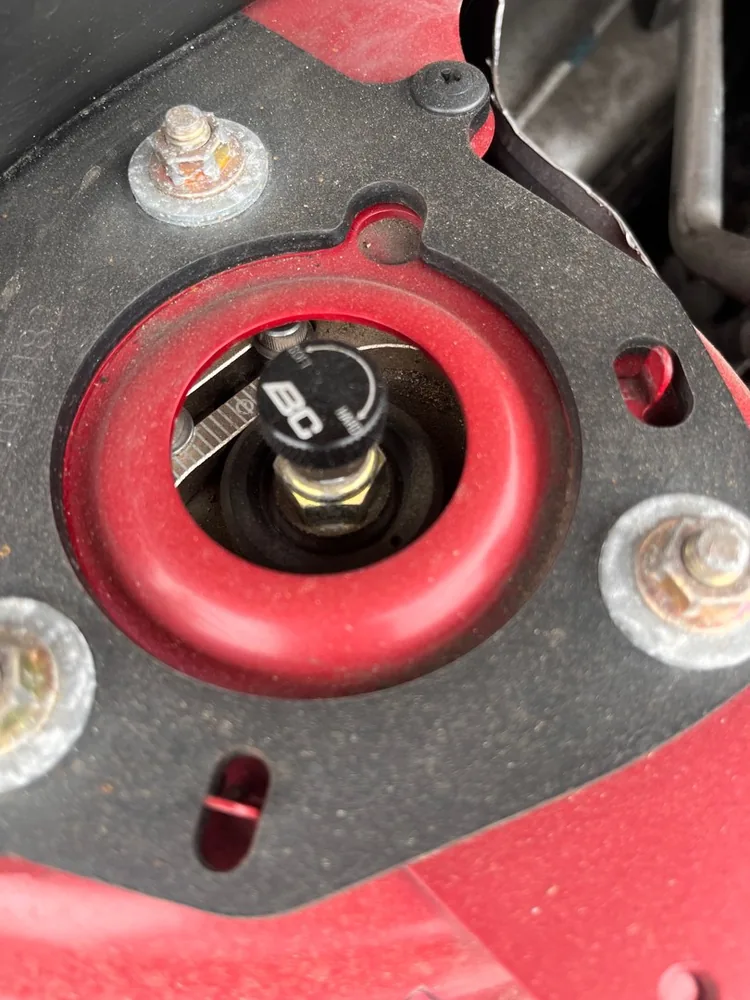 A red strut mount and top nut close up