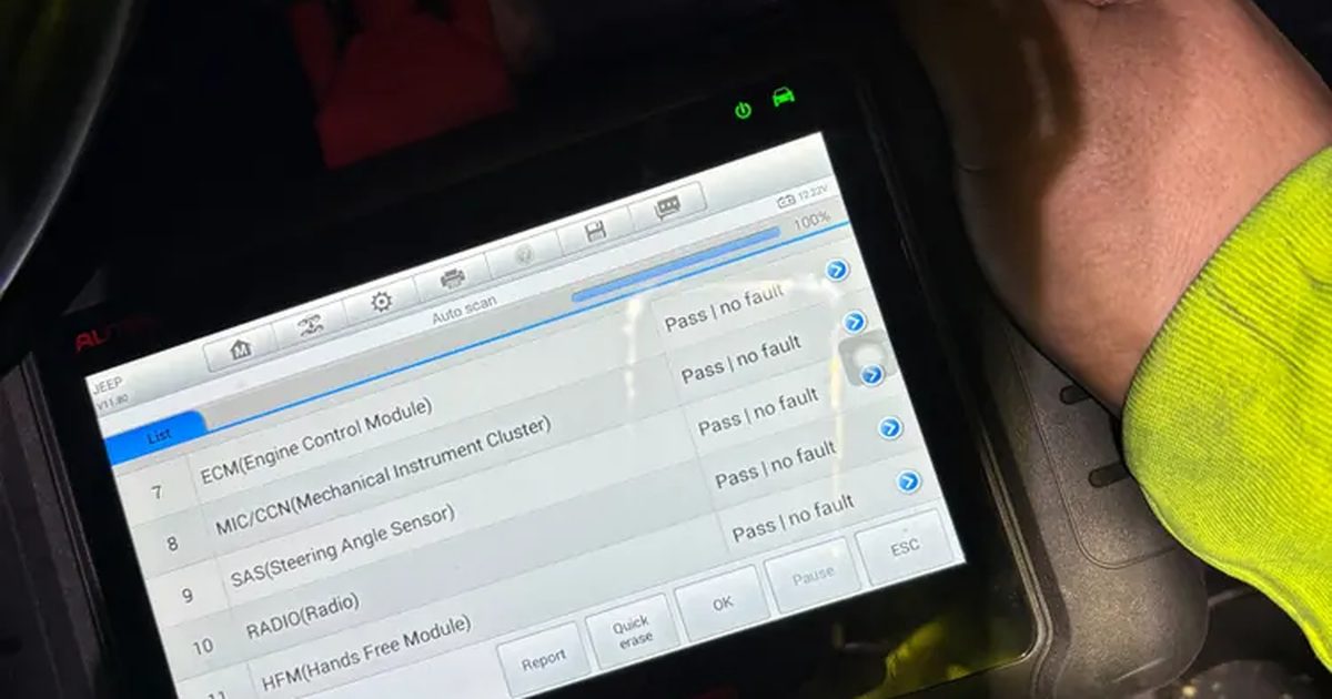 A scan tablet under the dash of a Jeep showing a full scan of every module