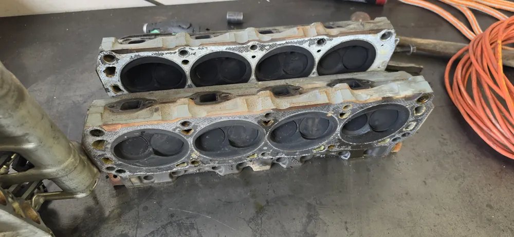 Two cylinder heads on the shop floor after being pulled off an engine