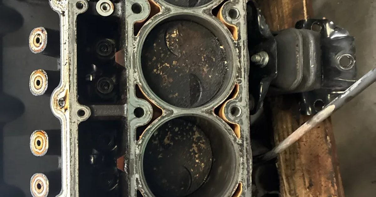 An engine block out of the car with the heads off and the cylinders showing